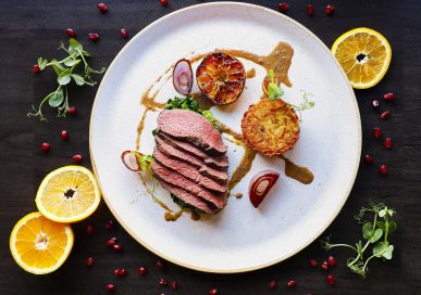 Pan seared loin of Lincolnshire venison with summer greens, crispy potato rostï, charred clementine and juniper sauce.