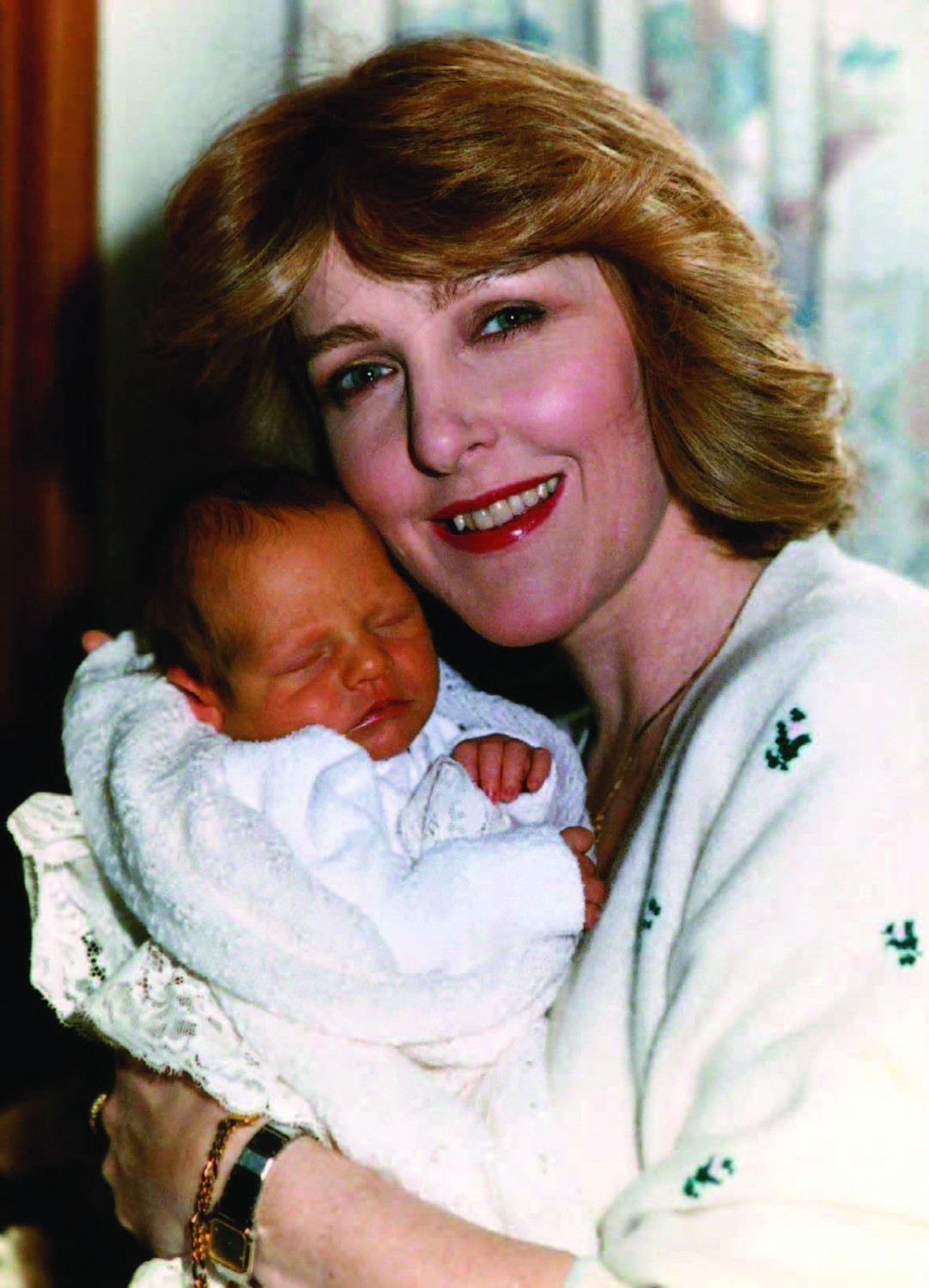 Portrait of stage and screen actor Patricia Hodge holding a baby.